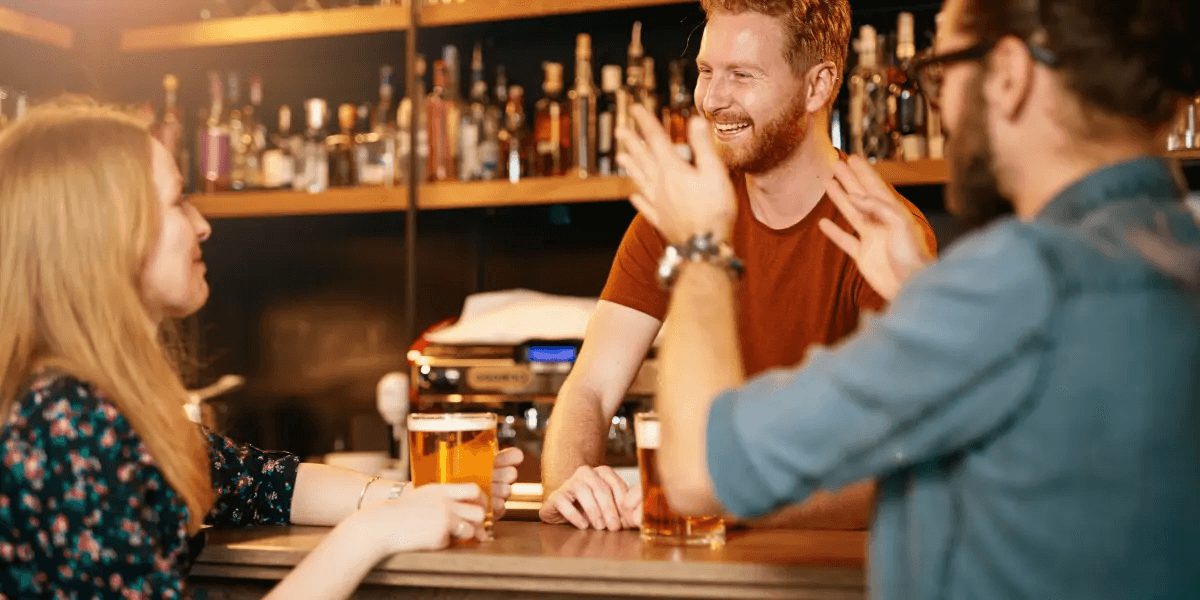 two people chatting with the bartender for beer recommendations