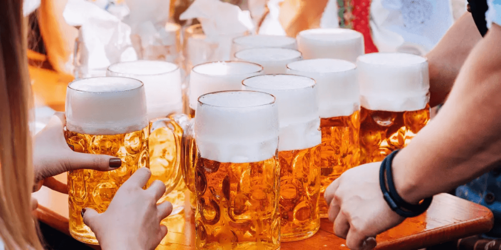several mugs filled with beer being served