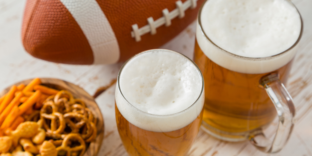 Two glasses of beer next to a football, symbolizing American-made beer