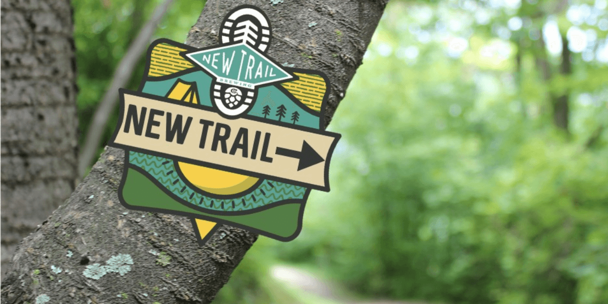 A trail marker with the logo of New Trail Brewing Co.