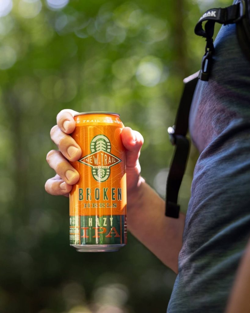 Broken Heels Hazy IPA held by a hiker