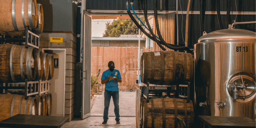 man standing near beer kegs