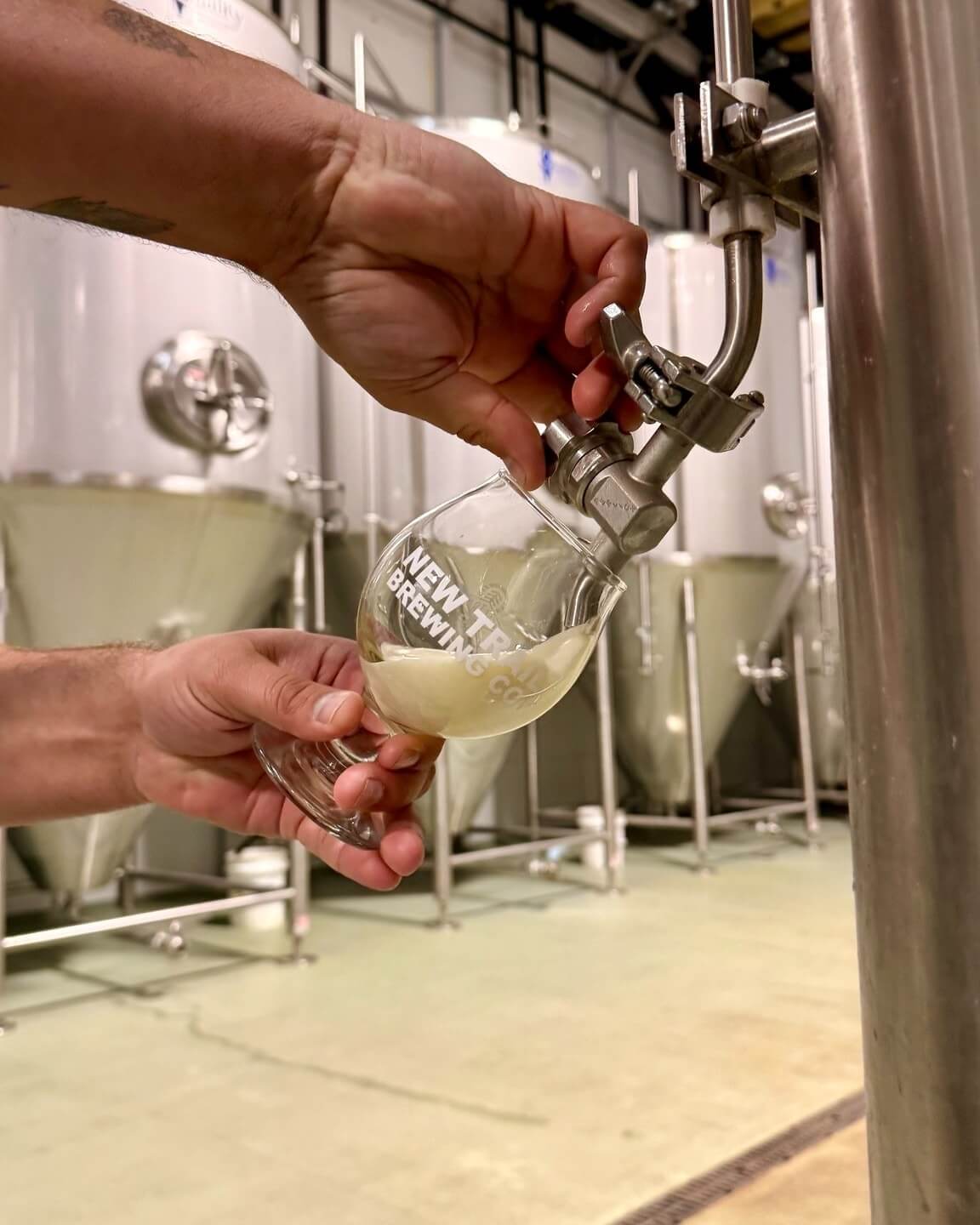 New Trail brewer pouring onto glass directly from vat